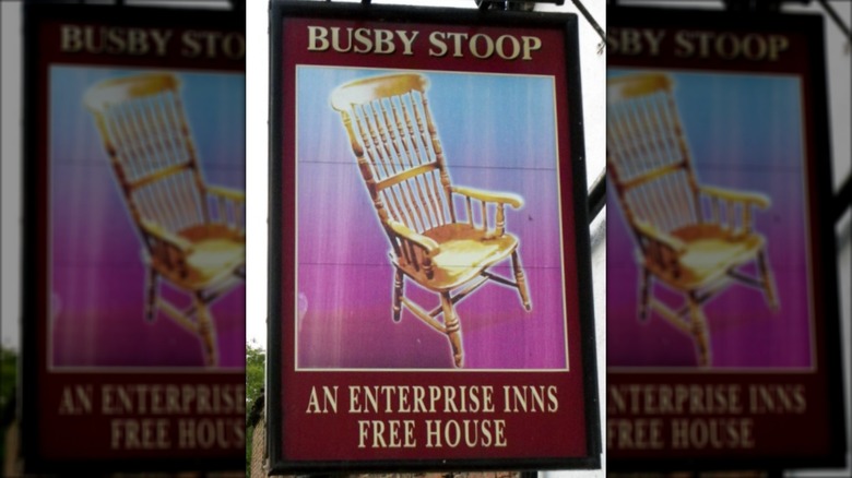Señal de la taberna Busby Stoop con silla
