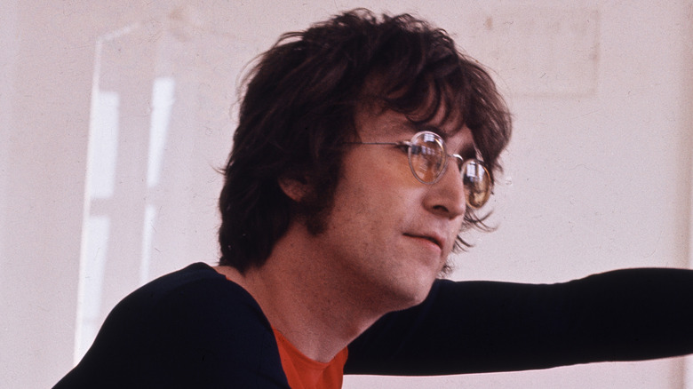 John Lennon en perfil en una habitación blanca en los 70