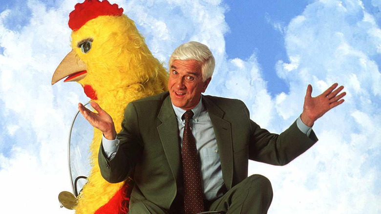 Leslie Nielsen en moto con una persona disfrazada de pollo
