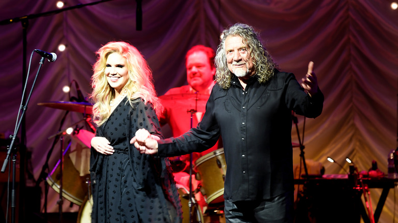 Alison Krauss et Robert Plant se tenant la main sur scène