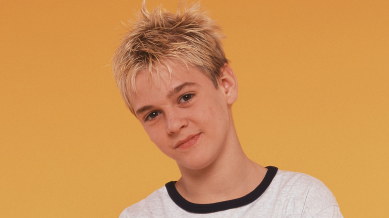 Aaron Carter sonriendo en una camiseta en una foto promocional