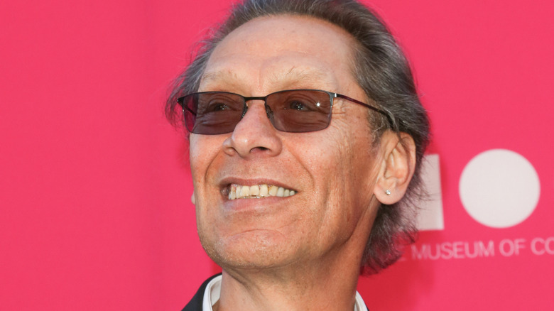 Alex Van Halen con gafas oscuras sonriendo
