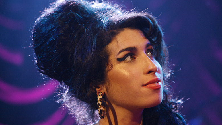 Amy Winehouse sonriendo y mirando hacia arriba