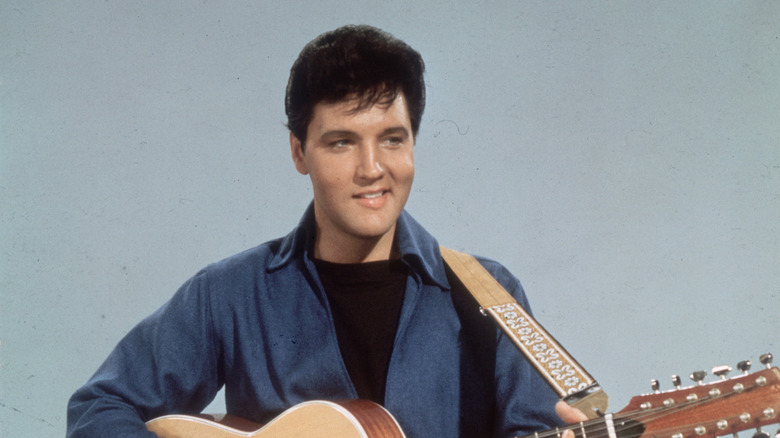 Elvis Presley sonriendo con guitarra