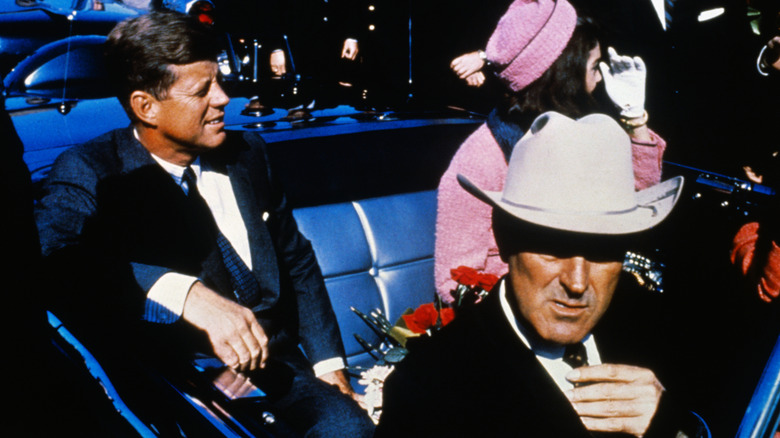 Primer plano de Kennedy en el coche con Jackie en Dallas