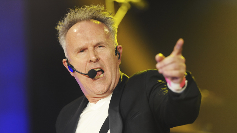 Howard Jones en concierto señalando mientras canta