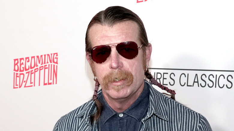 Jesse Hughes con gafas de sol y traje de rayas