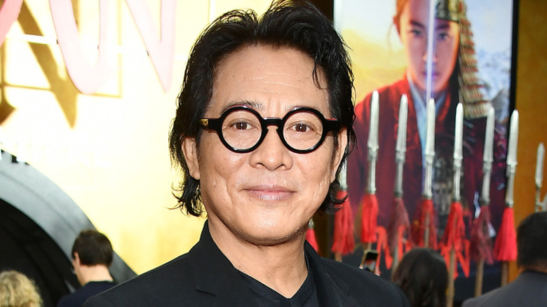Jet Li sonriendo con gafas grandes