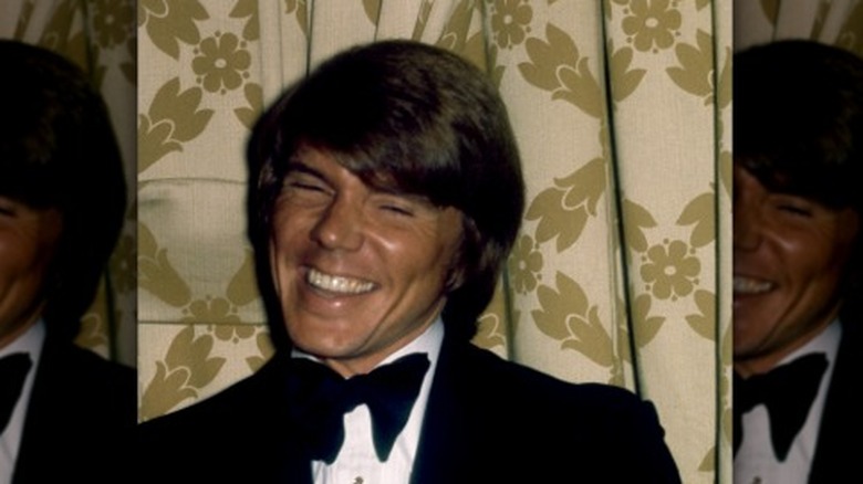 John Davidson sonriendo con moño