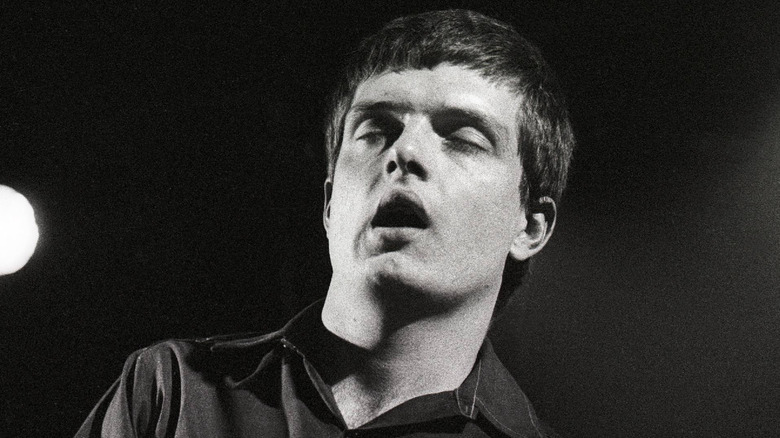 Ian Curtis bailando en escenario con ojos cerrados