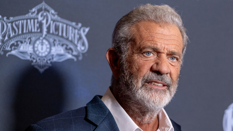 Mel Gibson con barba en un fondo gris-azul