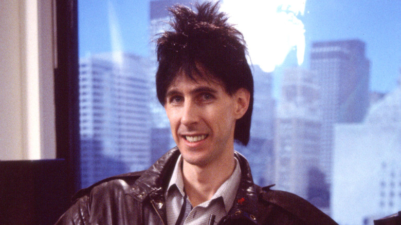 Ric Ocasek sonriendo frente a ventana