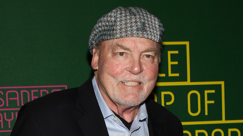 Stacy Keach con expresión de dolor en la cabeza