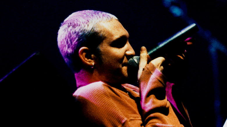 Layne Staley cantando, recostado con suéter naranja