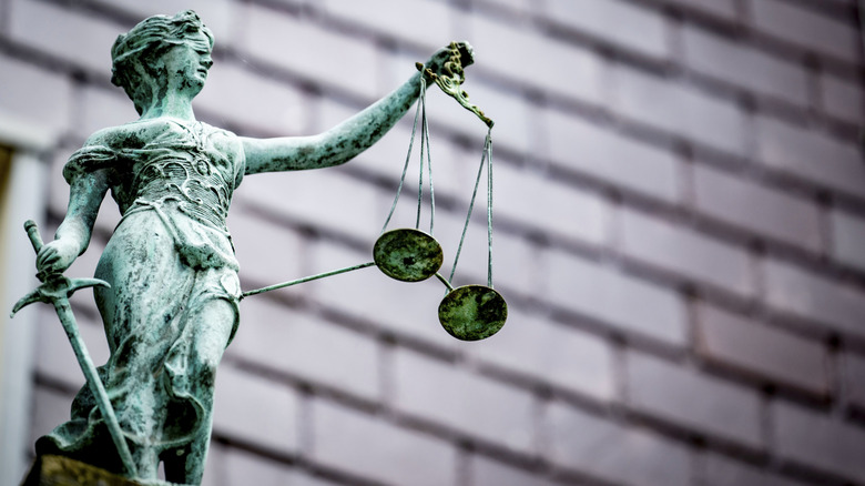 Estatua de justicia sosteniendo balanza