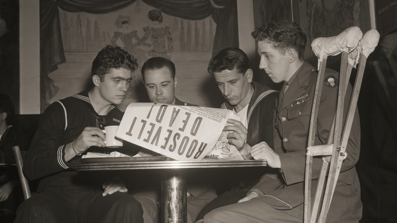 Cuatro militares leyendo el periódico con la noticia de la muerte de FDR