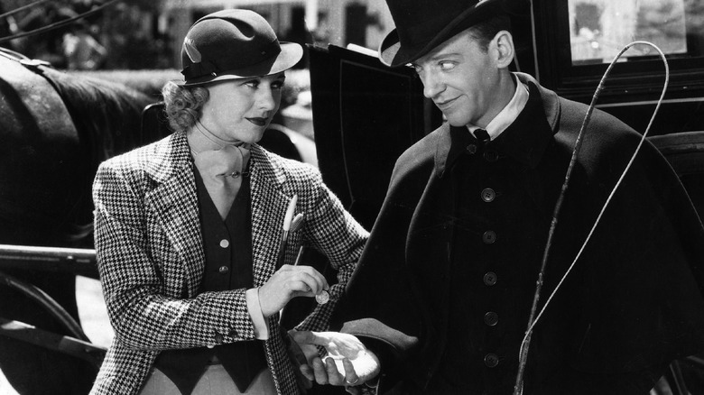 Ginger Rogers dándole una moneda a Fred Astaire