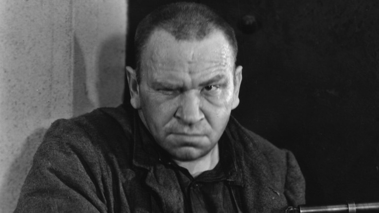 Wallace Beery en un retrato en un muro oscuro