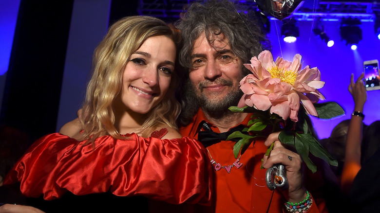Wayne Coyne sosteniendo una gran flor con Katy Weaver