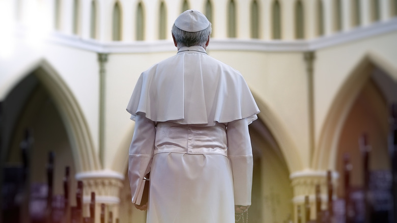 Papa sosteniendo una Biblia en la iglesia