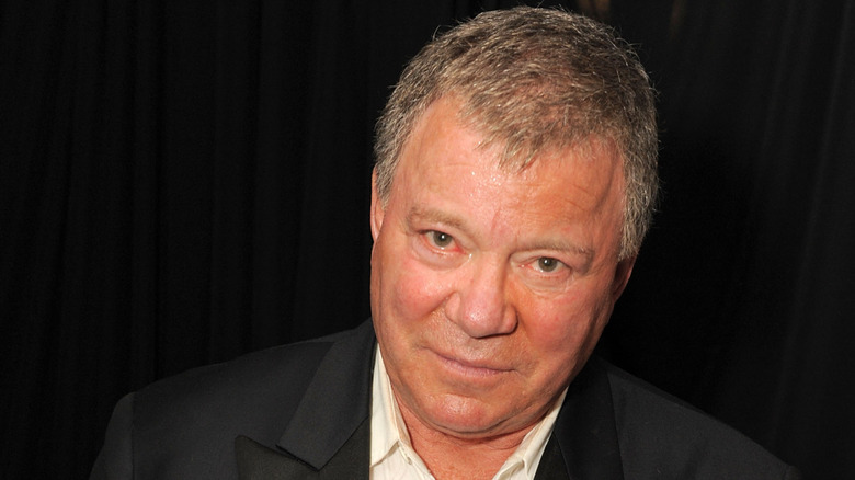 Primer plano de William Shatner frente a una cortina negra