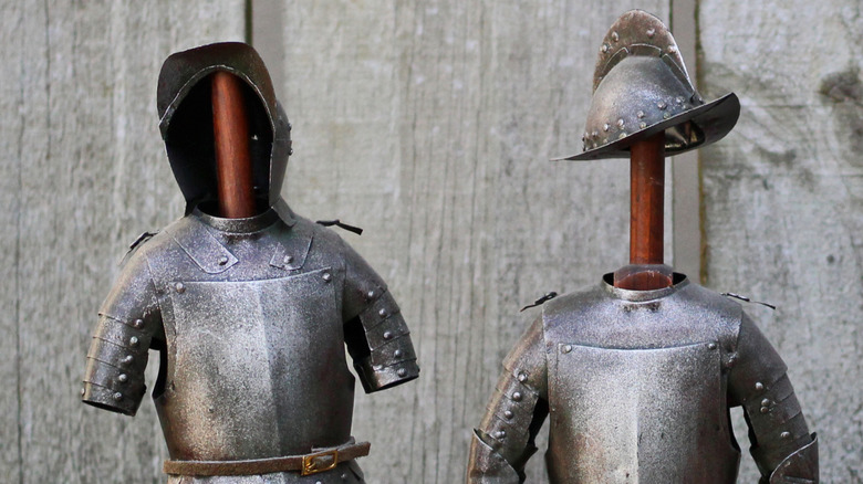 Trajes de armadura en postes de madera